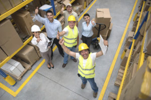 Workers at a warehouse with thumbs up